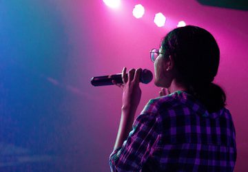 Woman onstage holding a microphone