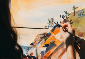 Woman painting a nature scene outside